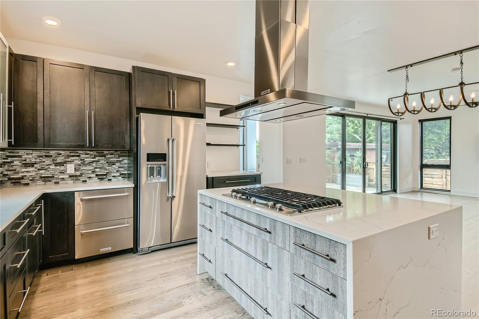 1609 Xavier Street Denver, CO 80204 - Photo 10 of 36 a kitchen with stainless steel appliances granite countertop a stove and a refrigerator