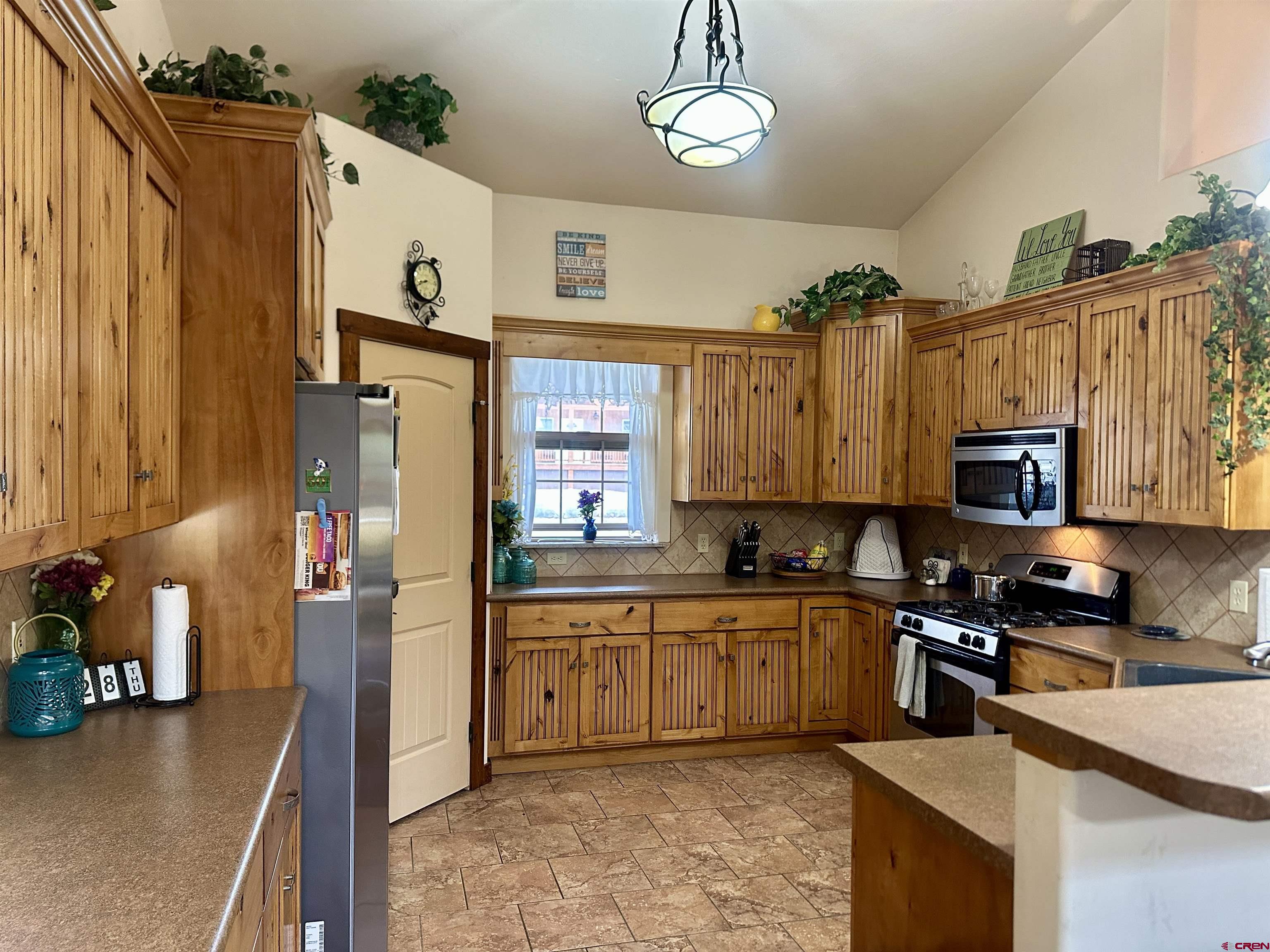 515 Southeast 2nd Street Cedaredge, CO 81413 - Photo 11 of 35 a kitchen with stainless steel appliances granite countertop a sink a stove and a refrigerator