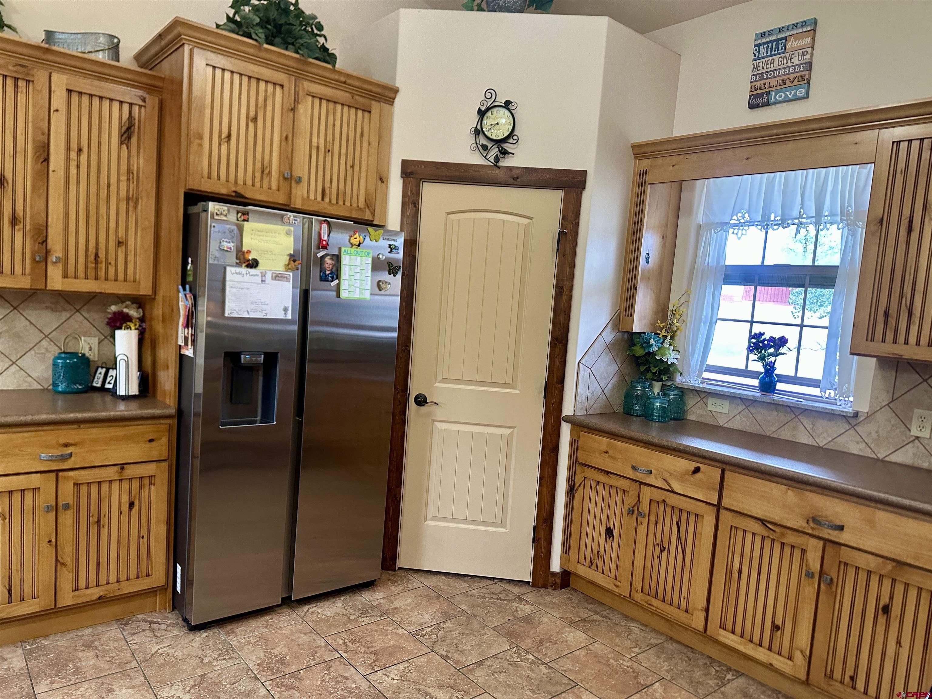515 Southeast 2nd Street Cedaredge, CO 81413 - Photo 14 of 35 a kitchen with stainless steel appliances granite countertop a refrigerator a oven and white cabinets with wooden floors