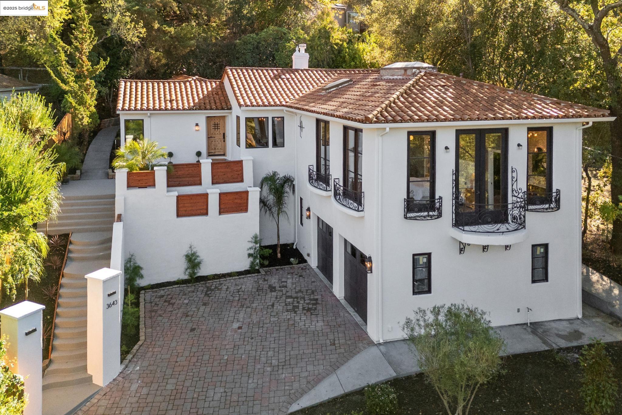 a view of a white house with large windows next to a white house