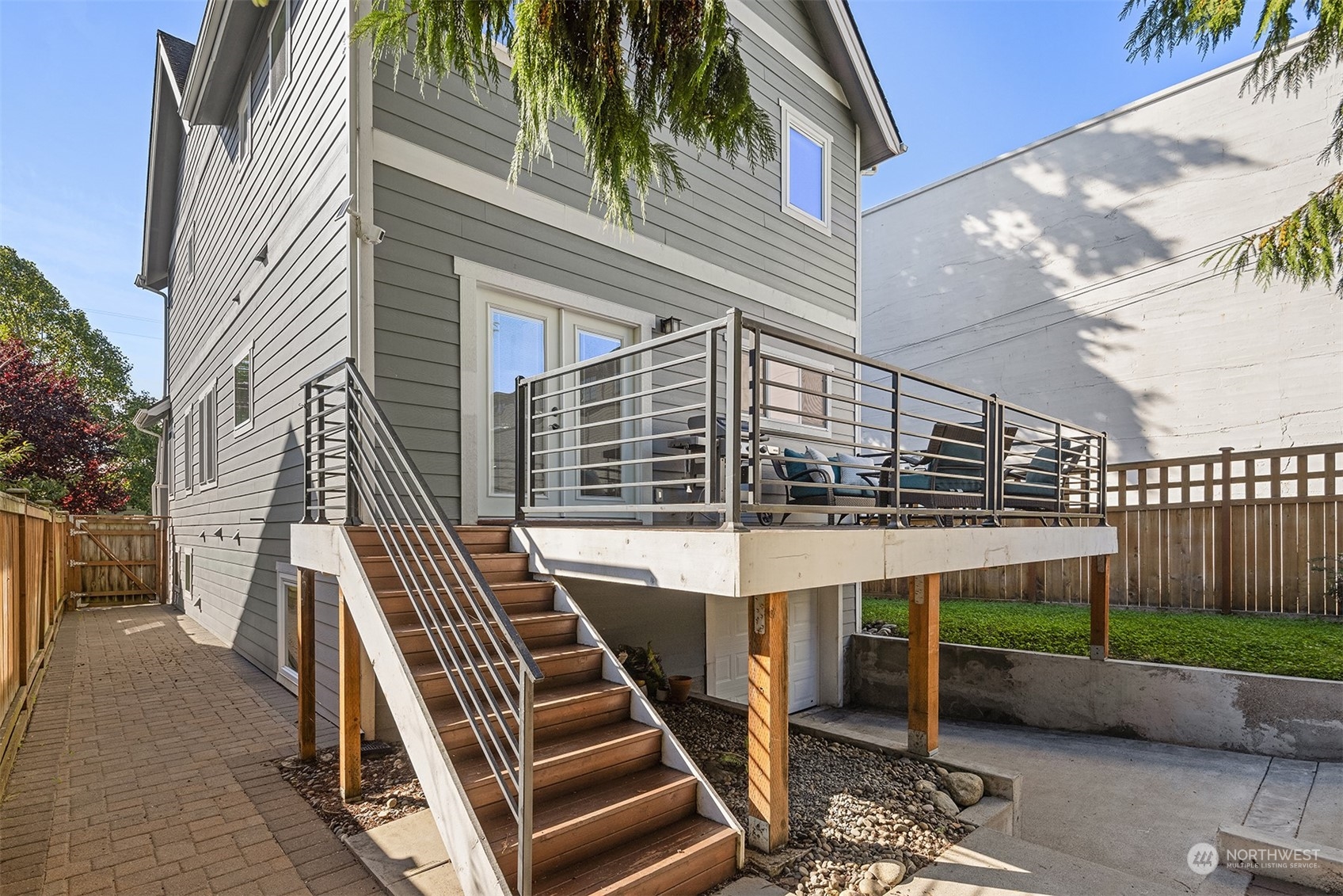 1112 North 76th Street Seattle, WA 98103 - Photo 31 of 40 a view of a patio with table and chairs with wooden floor and fence