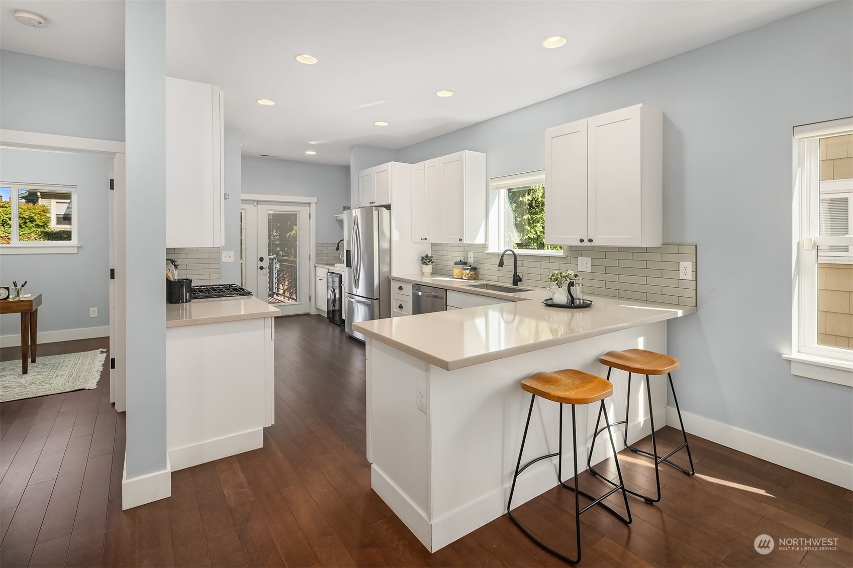 1112 North 76th Street Seattle, WA 98103 - Photo 9 of 40 a kitchen with stainless steel appliances granite countertop a stove a sink a refrigerator and a dining table with wooden floor
