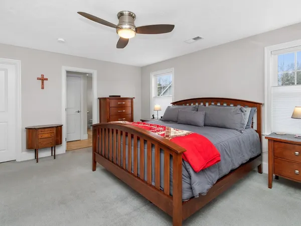 a bedroom with a bed and a lamp on the dresser