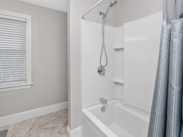 a white bath tub sitting next to a white sink and vanity