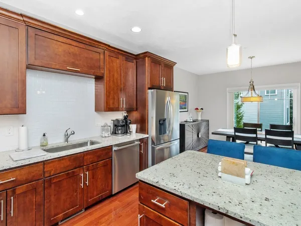 a kitchen with stainless steel appliances wooden cabinets a sink and a refrigerator