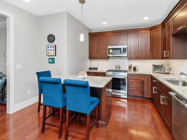 a kitchen with stainless steel appliances wooden floors and wooden cabinets