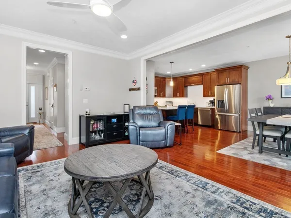 a living room with furniture a large window and dining table