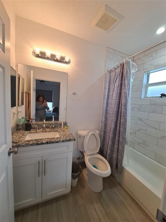 1635 West 15th Street Riviera Beach, FL 33404 - Photo 12 of 26 a bathroom with a granite countertop sink toilet a mirror and shower