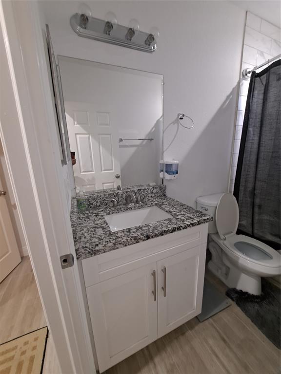 1635 West 15th Street Riviera Beach, FL 33404 - Photo 15 of 26 a bathroom with a granite countertop sink toilet and a mirror