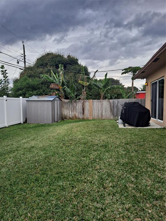 1635 West 15th Street Riviera Beach, FL 33404 - Photo 23 of 26 a view of a backyard with potted plants and a large tree