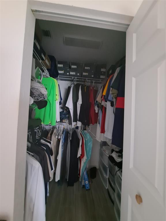 1635 West 15th Street Riviera Beach, FL 33404 - Photo 10 of 26 a view of walk in closet with clothes and shoes