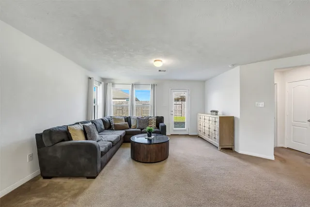 a living room with furniture and a ceiling fan