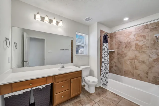 a bathroom with a double vanity sink toilet and shower