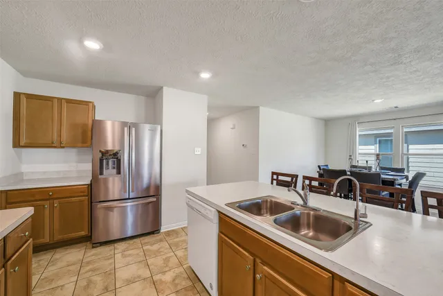 a kitchen with granite countertop a sink and refrigerator