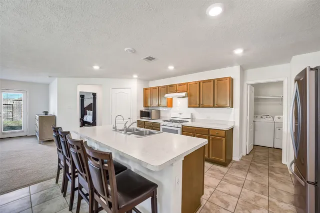 a kitchen with a table chairs refrigerator and cabinets