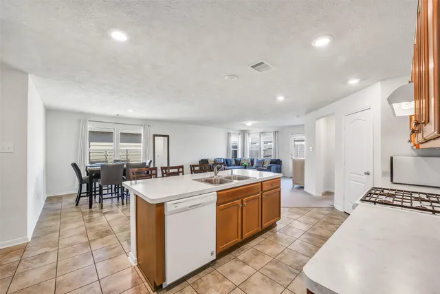 a large kitchen with kitchen island a sink table and chairs