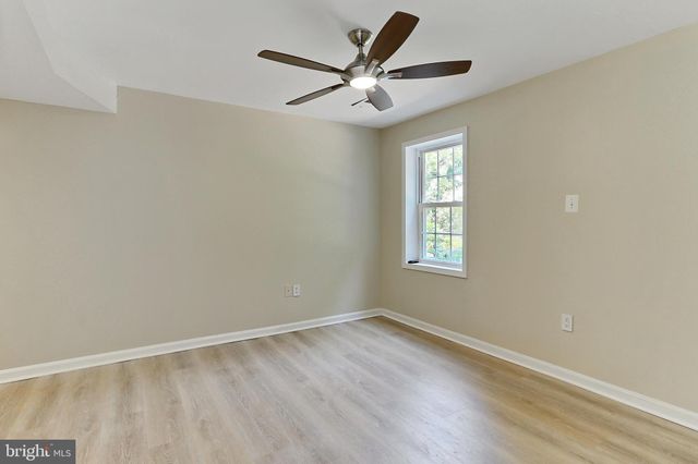 a view of a room with wooden floor and ceiling fan