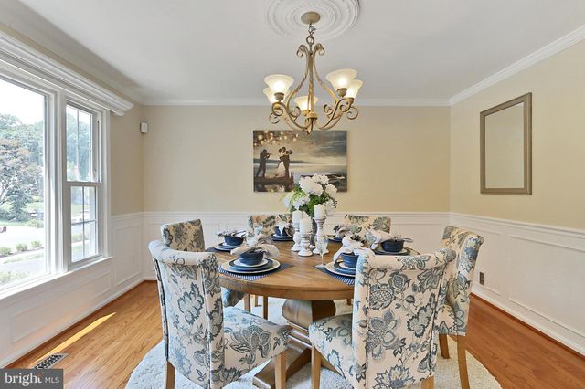 a view of a dining room with furniture a chandelier and wooden floor