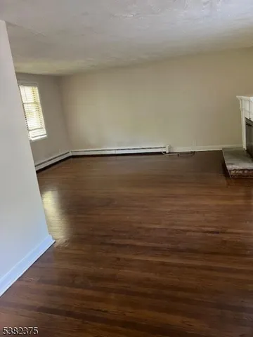 a living room with wooden floor and a fireplace