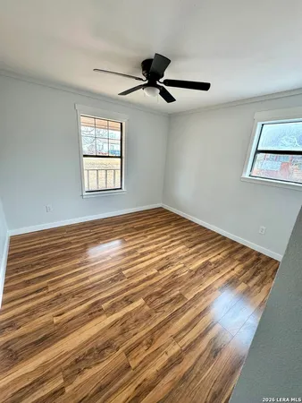 a view of empty room with window and ceiling fan