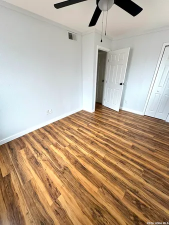 a view of a bedroom with wooden floor