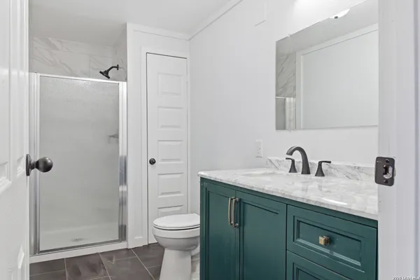 a bathroom with a granite countertop sink toilet and shower
