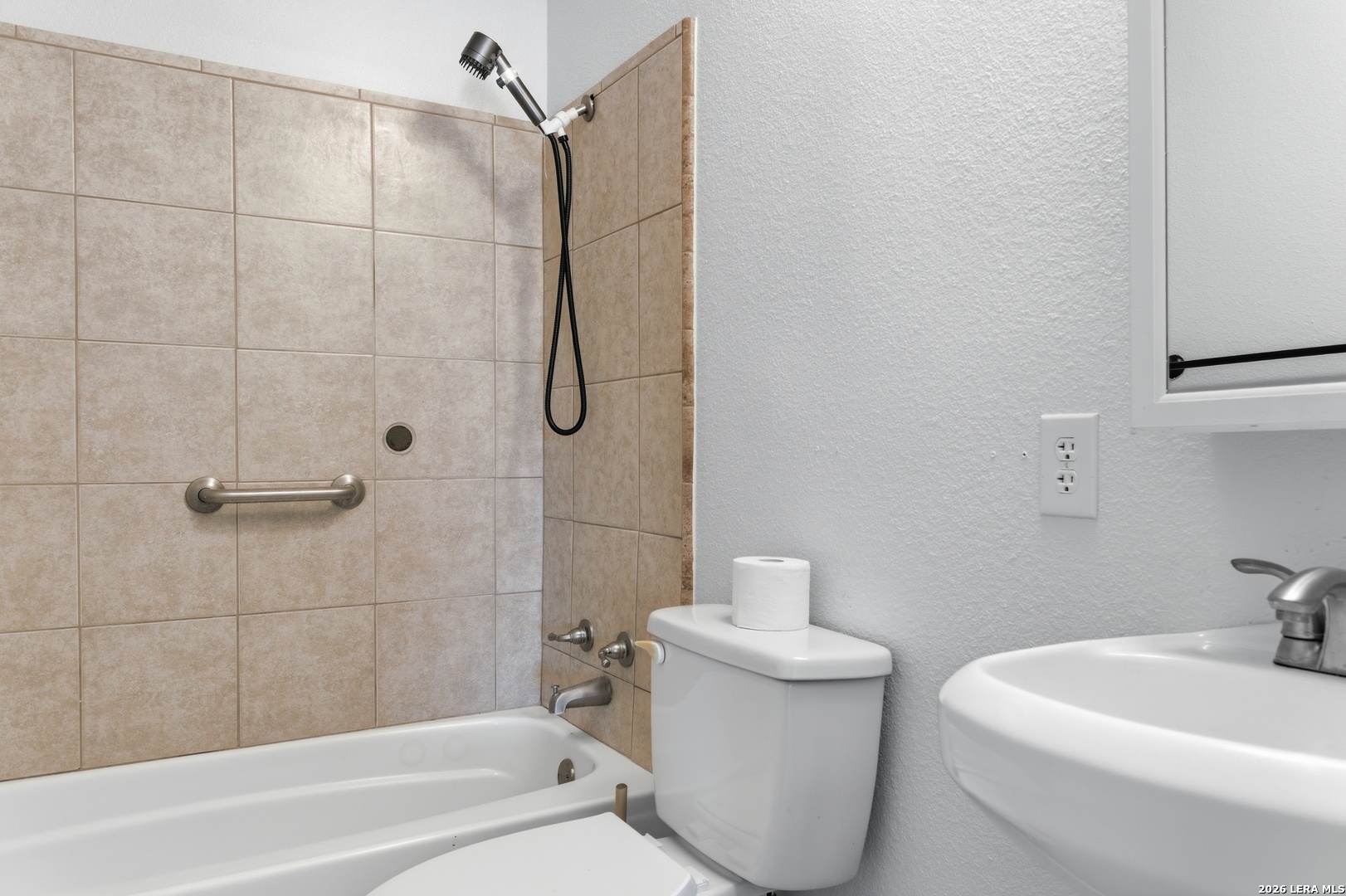 910 Cypress Street Jourdanton, TX 78026 - Photo 24 of 25 a bathroom with a sink a toilet and shower