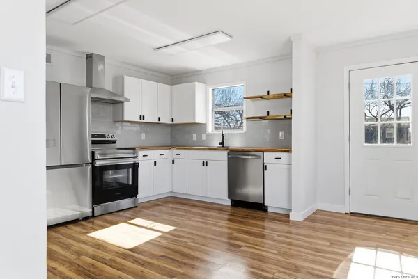 a kitchen with granite countertop white cabinets and appliances