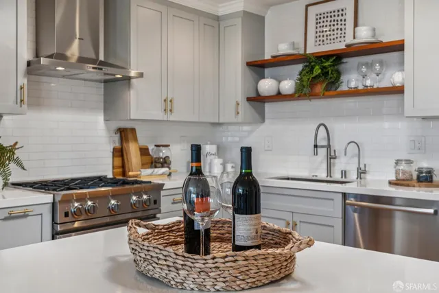 a kitchen with stainless steel appliances granite countertop a sink a stove and wooden cabinets