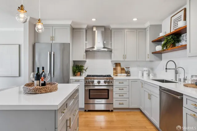 a kitchen with stainless steel appliances kitchen island granite countertop a stove and white cabinets