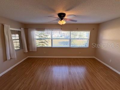 9759 Southwest 97th Lane Ocala, FL 34481 - Photo 11 of 28 an empty room with wooden floor chandelier and windows