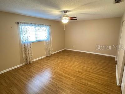 9759 Southwest 97th Lane Ocala, FL 34481 - Photo 17 of 28 an empty room with wooden floor fan and windows