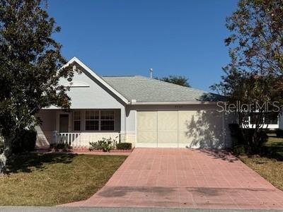 9759 Southwest 97th Lane Ocala, FL 34481 - Photo 2 of 28 a front view of a house with garden