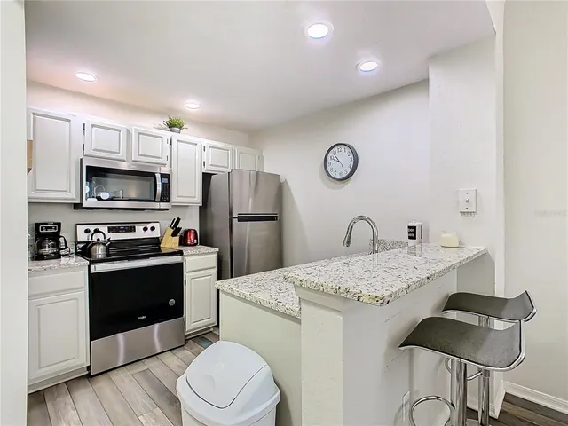 a kitchen with a refrigerator and a stove top oven