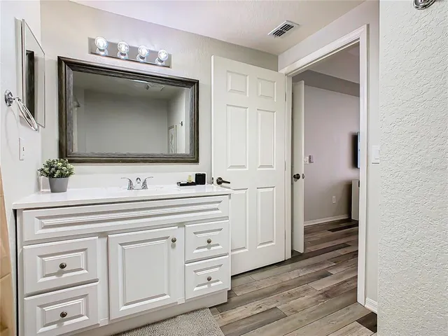 a bathroom with a sink vanity and mirror