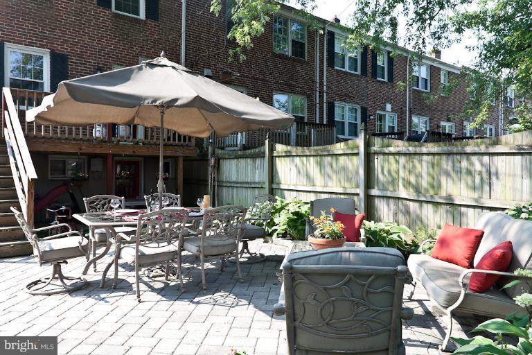 182 Brandon Road Baltimore, MD 21212 - Photo 20 of 30 a view of a patio with couches table and chairs under an umbrella