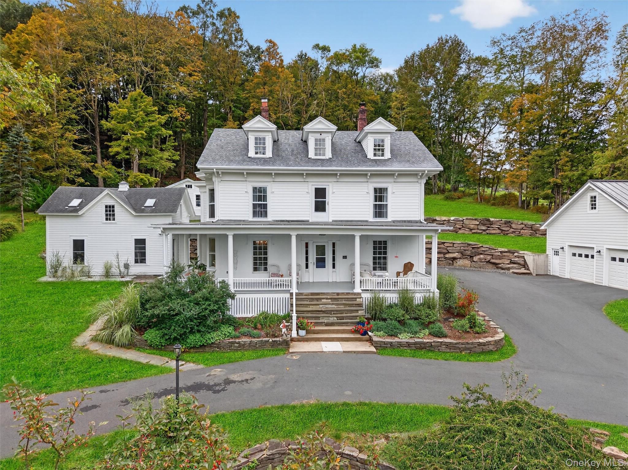 a front view of a house with a garden and plants