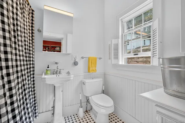 a bathroom with a sink toilet and window