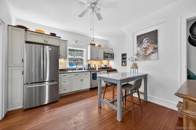 a kitchen with stainless steel appliances wooden floor and dining table