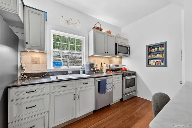 a kitchen with granite countertop a stove a sink and a microwave