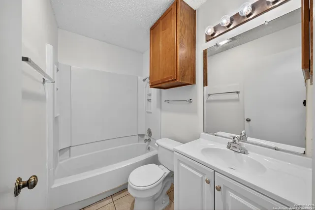 a bathroom with a granite countertop sink a toilet and shower