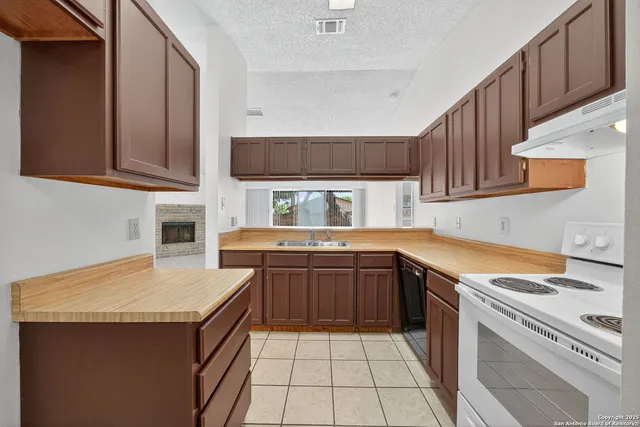 a kitchen with stainless steel appliances granite countertop a sink stove and cabinets