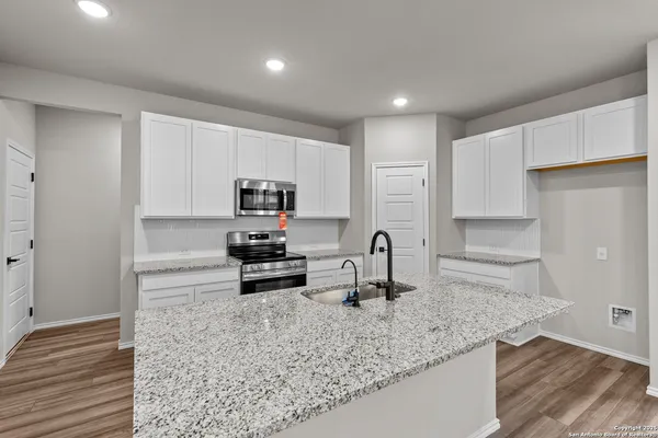 a kitchen with stainless steel appliances granite countertop a sink stove and cabinets