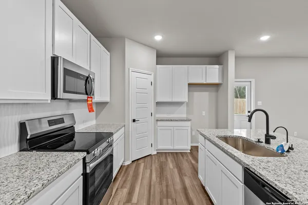 a kitchen with granite countertop a sink stainless steel appliances and cabinets