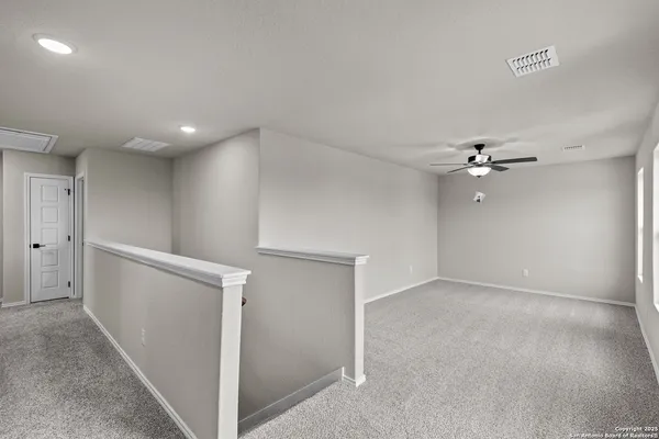 wooden floor in an empty room with a ceiling fan