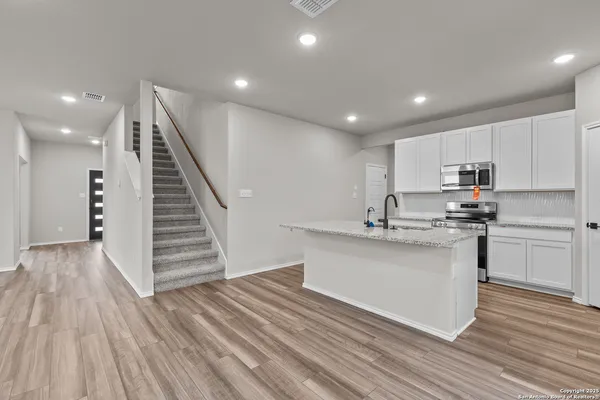 a kitchen with granite countertop a sink and a stove top oven