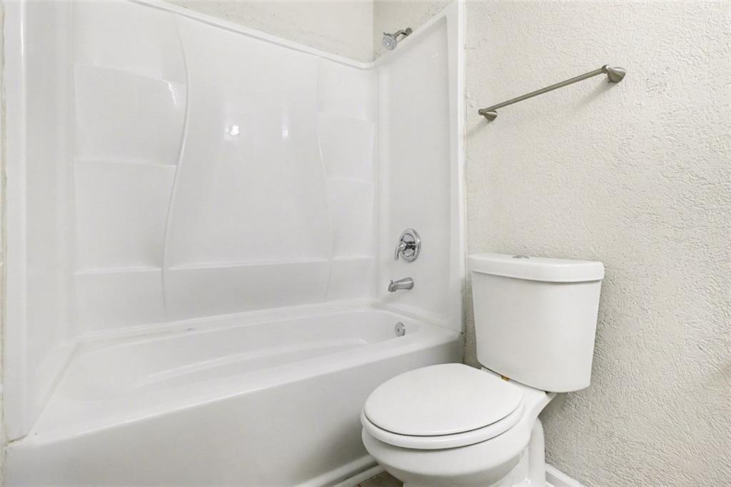 5474 Panola Downs Road Lithonia, GA 30058 - Photo 16 of 27 a white toilet sitting next to a bath tub