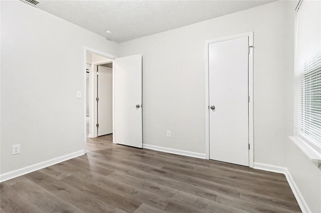 5474 Panola Downs Road Lithonia, GA 30058 - Photo 18 of 27 an empty room with wooden floor and windows