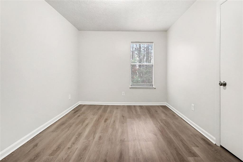 5474 Panola Downs Road Lithonia, GA 30058 - Photo 20 of 27 an empty room with wooden floor and windows
