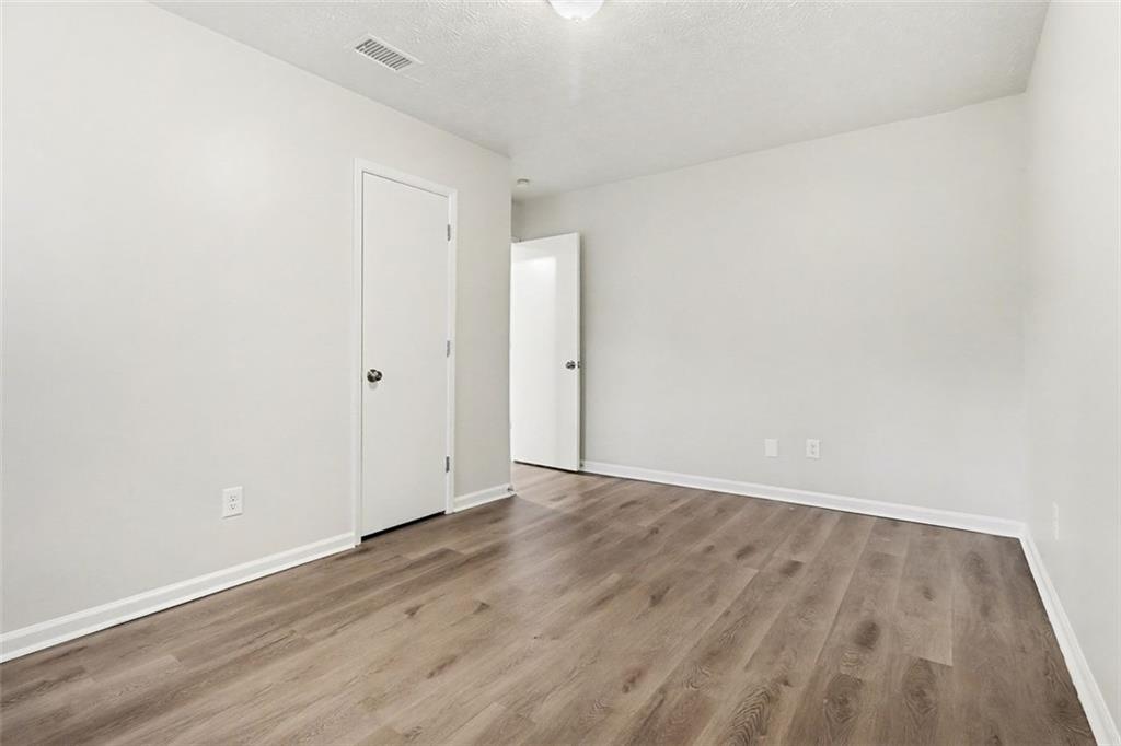5474 Panola Downs Road Lithonia, GA 30058 - Photo 21 of 27 a view of an empty room with wooden floor
